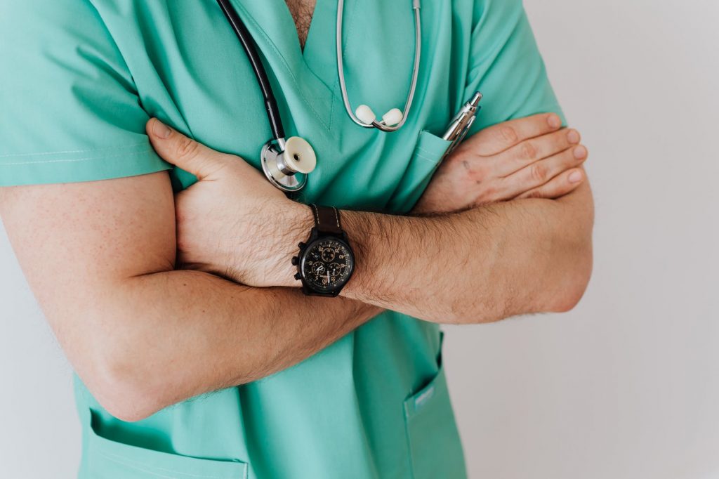 unrecognizable crop man in wristwatch with stethoscope